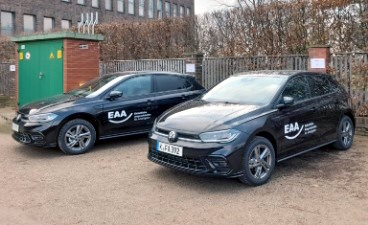 Einheitliche Ansprechstellen für Arbeitgeber Zwei schwarze Autos mit weißem EAA-Logo auf der Fahrertür stehen nebeneinander.