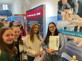 Berufsorientierungsmesse Foto: Vier junge Frauen stehen am Stand der FAW auf der Berufsorientierungsmesse