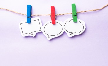 Schulungsangebot 2026 Integrationsamt Schleswig-Holstein Bildhafte Darstellung dreier Sprechblasen, die mit verschiedenfarbigen Klammern an einer Schnur befestigt sind.